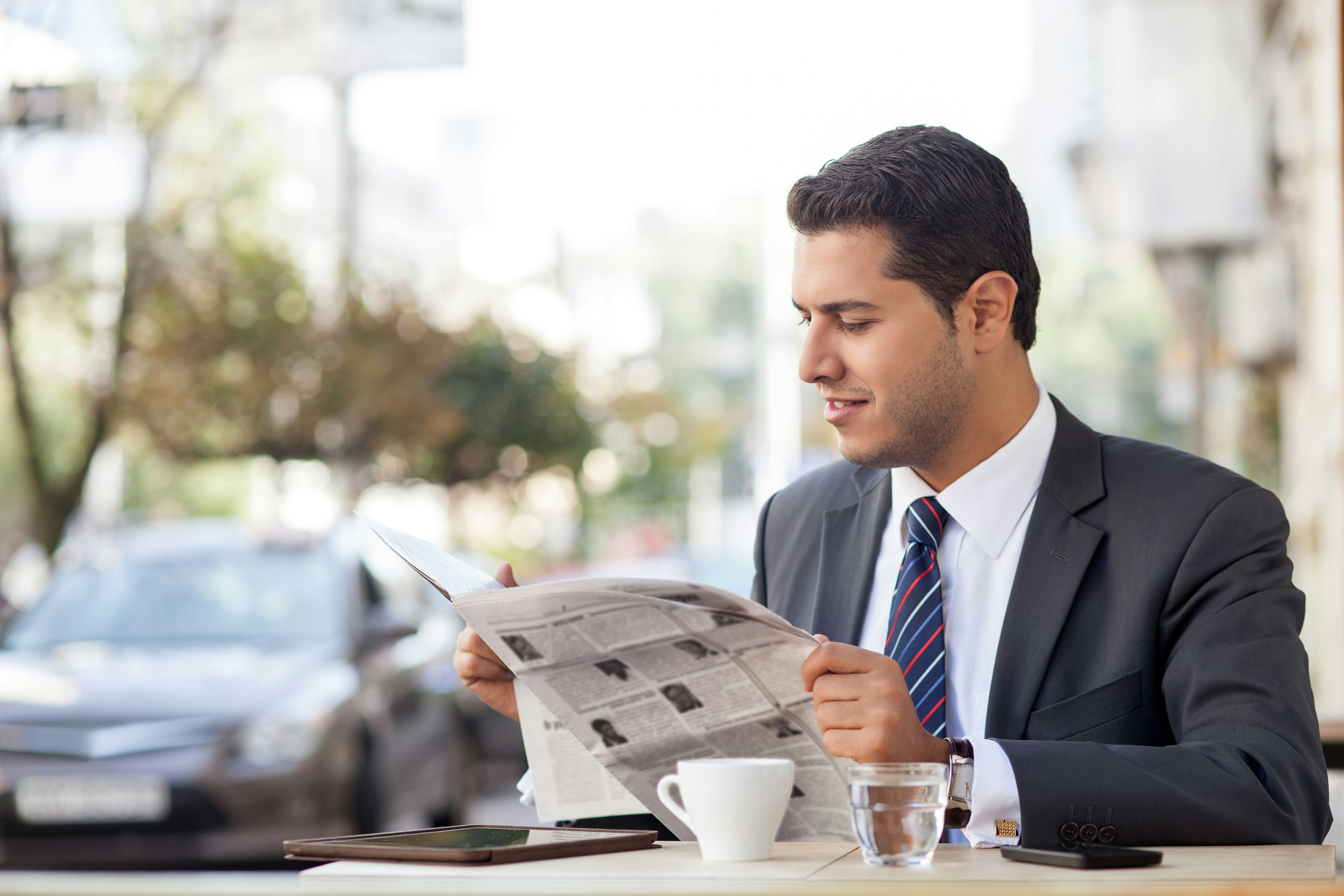 Digital detox man in suit reading a newspaper